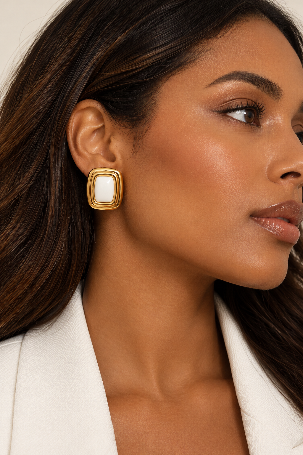 Model wearing THÖKERCO Safiya gold-tone stud earrings with ivory centre